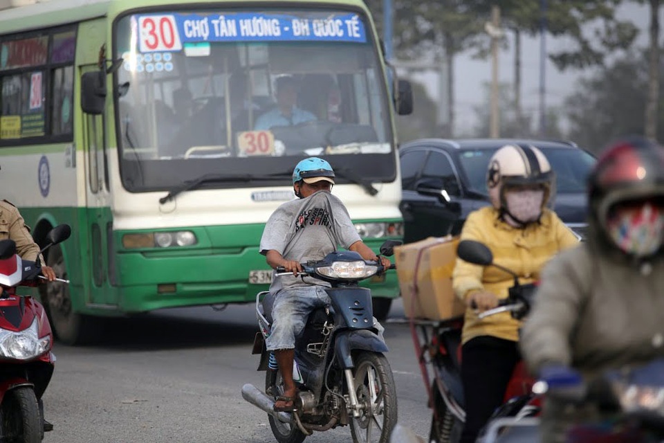 
Khi những chiếc xe lớn chạy qua, bụi càng thêm dày đặc. Người đàn ông trong ảnh dùng áo thay khẩu trang che mặt khi lưu thông qua đây.
