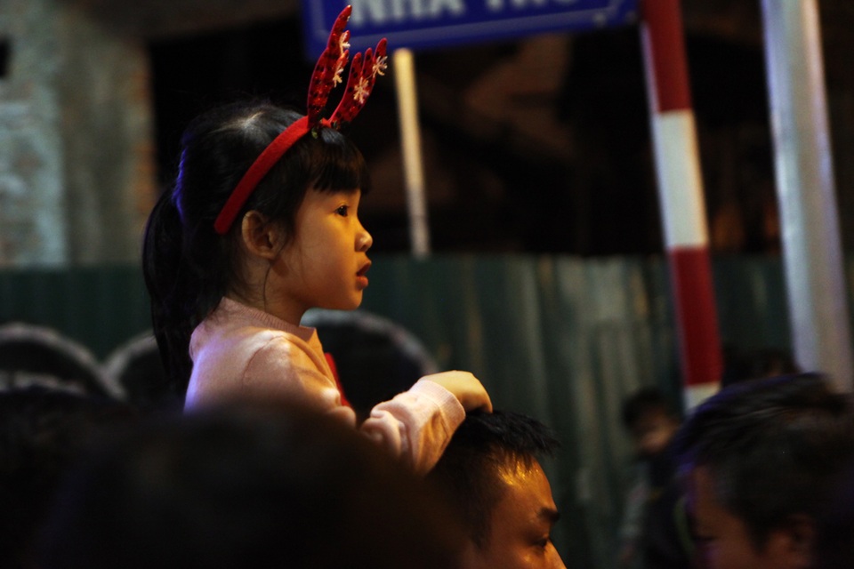 
Bé gái được cha mẹ cho đi chơi đêm Noel.
