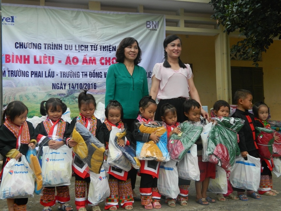 "Áo ấm cho em" đến với học sinh nghèo Bình Liêu - 3 Bà Nguyễn Thị Trực, đại diện Chi nhánh Vietravel tại Quảng Ninh trao quà cho các em nhỏ.