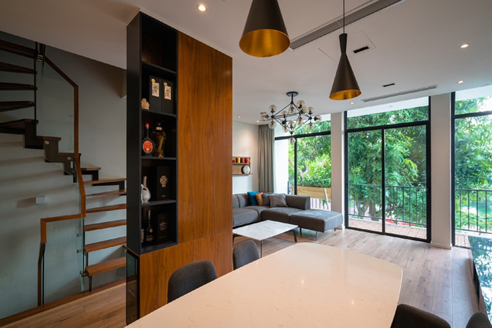 Cải tạo nhà 55m2 tù túng ở Hà Nội thành không gian cao cấp - 6
Toàn bộ không gian nội thất được thay đổi với cột giữa nhà được giấu trong vách tủ, tạo thành vách ngăn giữa phòng ăn và cầu thang. Tầm nhìn ở tầng 2 rộng hơn với cảnh quan bên ngoài. Dù là thư giãn ở sofa hay ngồi ở bàn phòng ăn đều có thể nhìn ra khuôn viên xanh mướt.