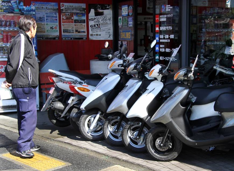 Yamaha muốn hiệp lực với Honda làm scooter 50 phân khối - 1
Một người đi đường dừng chân xem những chiếc xe tay ga Yamaha tại một đại lý ở Tokyo (Ảnh: Bloomberg)