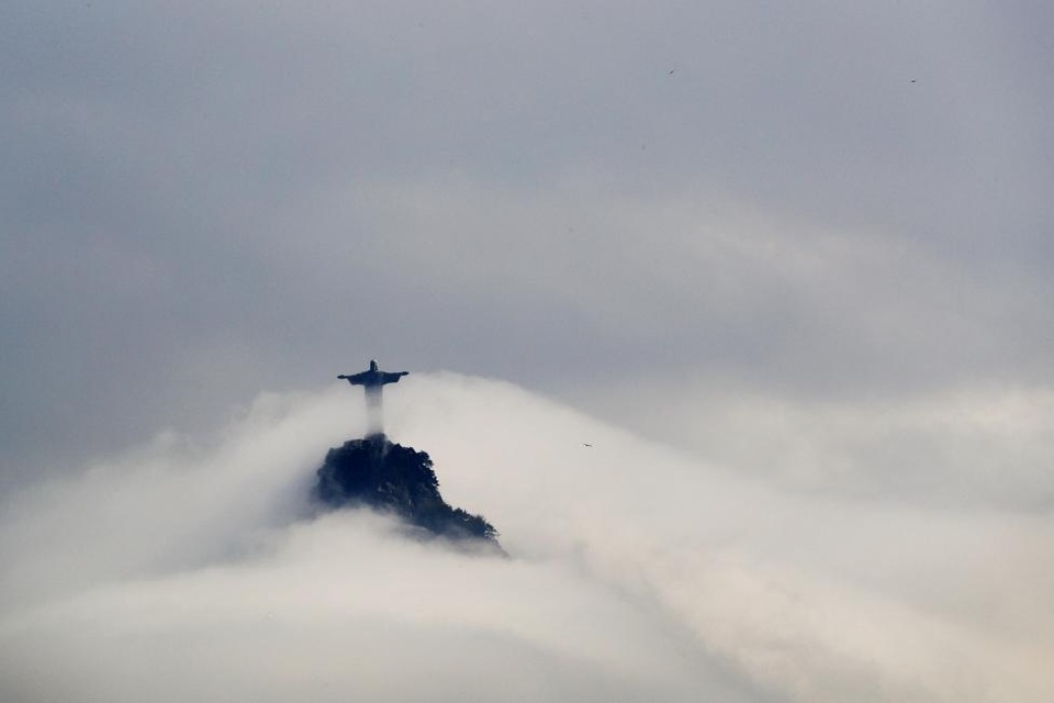 Thiếu nữ trong vườn đào được chọn làm ảnh ấn tượng Việt Nam trên Reuters - 9 Brazil: Những đám mây bao quanh tượng Chúa ở Rio de Janeiro, Brazil.