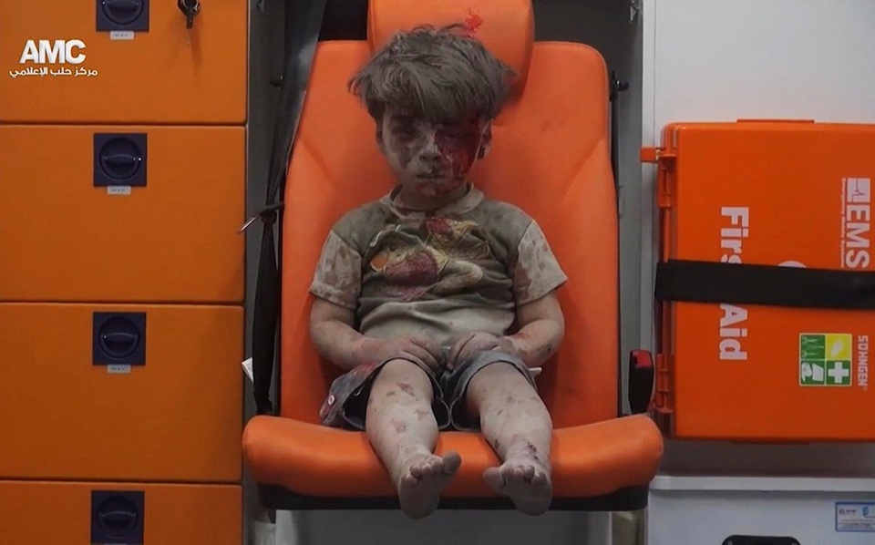 Thế giới năm 2016 qua ảnh (1) - 18 Bức ảnh chụp cậu bé Syria Omran Daqneesh, 5 tuổi, với gương mặt bê bết máu ngồi thẫn thờ trong xe cứu thương sau khi được các nhân viên cứu hộ đưa ra khỏi ngôi nhà bị phá hủy bởi các cuộc không kích của liên quân quốc tế ở Aleppo, đã trở thành biểu tượng cho sự tàn khốc của cuộc chiến tranh ở Syria năm qua.