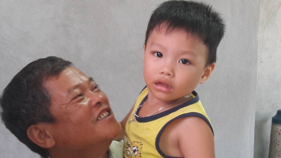 
Cậu bé Lê Đăng Khoa trong vòng tay của ông ngoại
