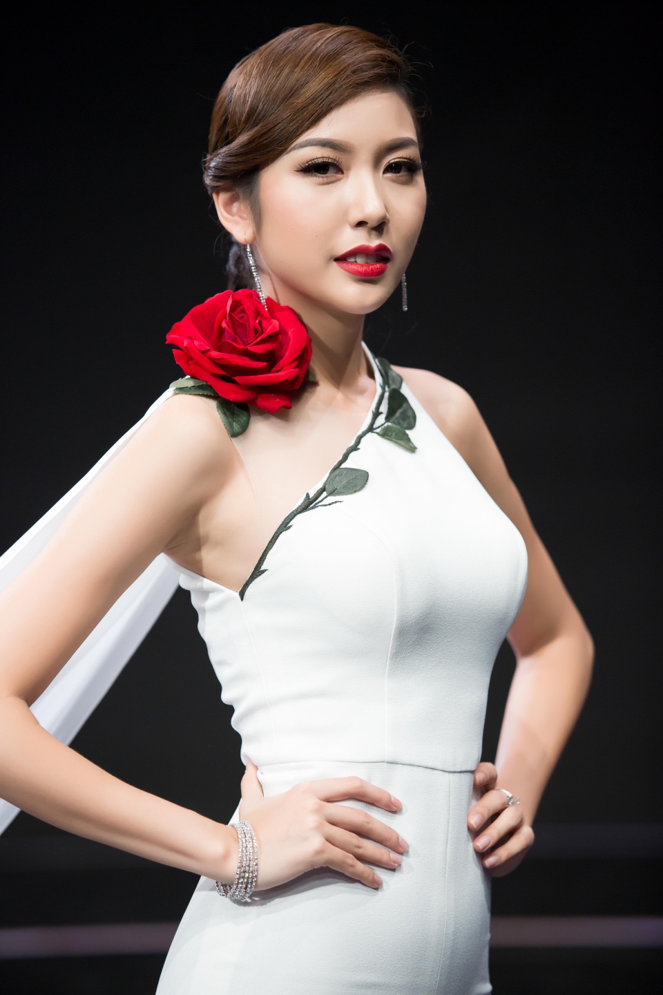 
Tổng thể trang phục đơn màu nhưng không nhàm chán bởi bông hoa hồng đỏ và layout make up sang trọng, cổ điển. Với kỹ thuật make-up tạo điểm nhấn vào bờ môi đỏ nổi bật và đôi mắt vẽ eyeliner đen đậm
