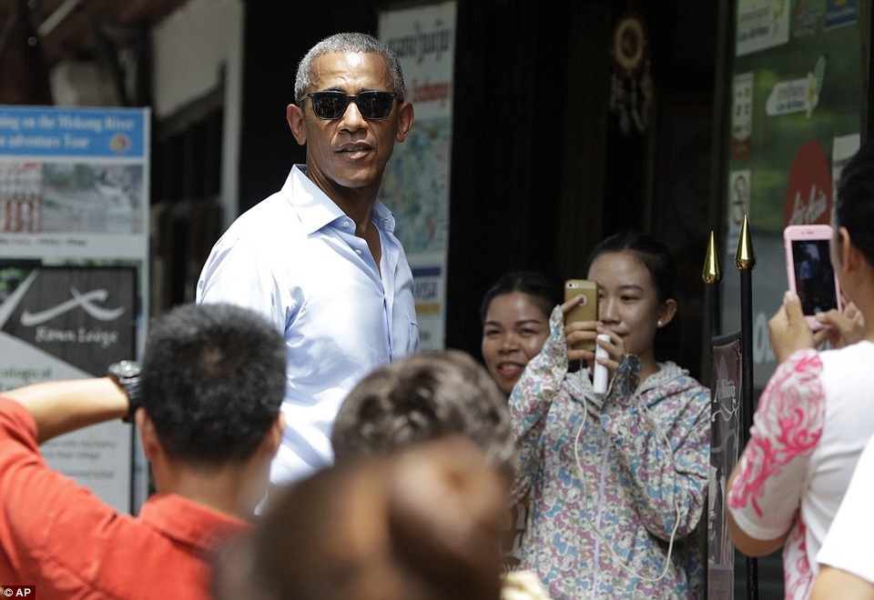 Tổng thống Obama dạo phố, uống nước dừa ở Lào - 2
Sau khi bước xuống chiếc Air Force One, đoàn xe chở Tổng thống Obama đã lướt qua các tuyến đường quanh thị trấn. Những người dân địa phương ở đây đứng thành từng nhóm nhỏ ở hai bên đường để vẫy chào ông.