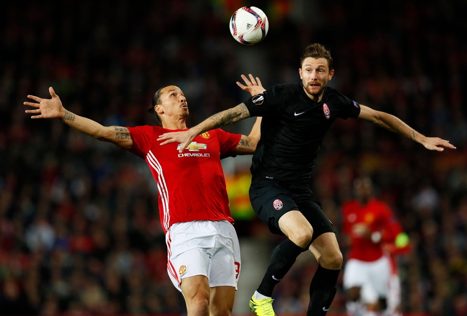 
Ibra (trái) tranh bóng trên không với Mikhail Savikov
