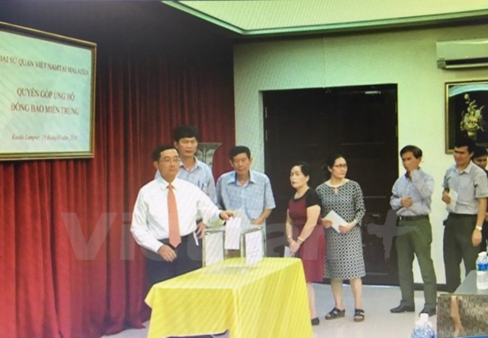 Cộng đồng người Việt ở nước ngoài quyên góp ủng hộ miền Trung - 5 Cán bộ nhân viên Đại sứ quán, đại diện các doanh nghiệp và cộng đồng người Việt Nam quyên góp tại lễ phát động. (Ảnh: Lê Hòa/Vietnam+)