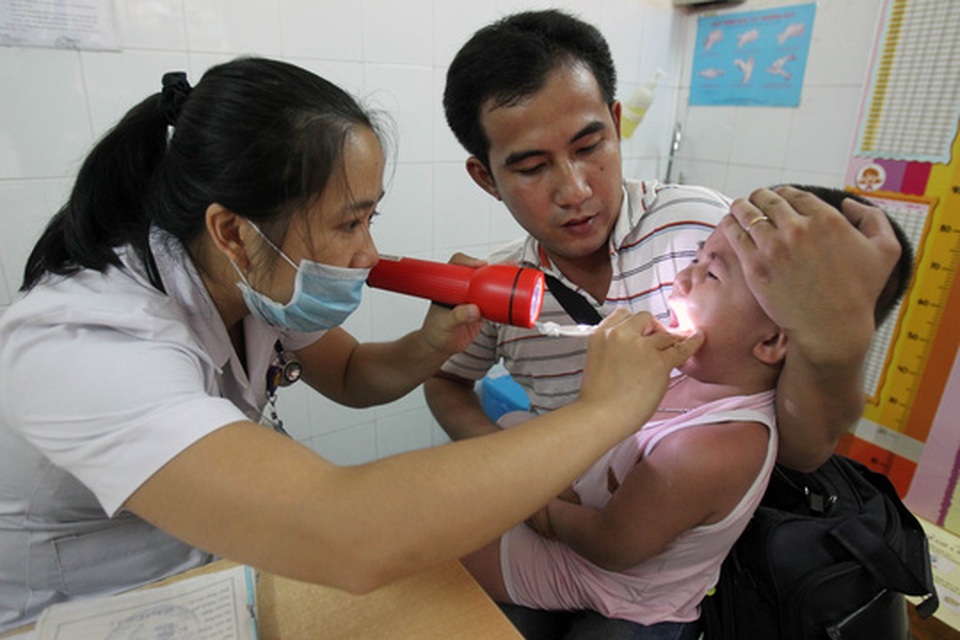 Đừng cứ sụt sịt là đến bác sĩ - 1 Trẻ cần được đưa đi khám nếu nghi ngờ các biến chứng như viêm phổi, suyễn, viêm tai giữa, viêm loét hầu họng…. Trong ảnh: Khám bệnh tại Bệnh viện Nhi Đồng 1. Ảnh: HOÀNG TRIỀU
