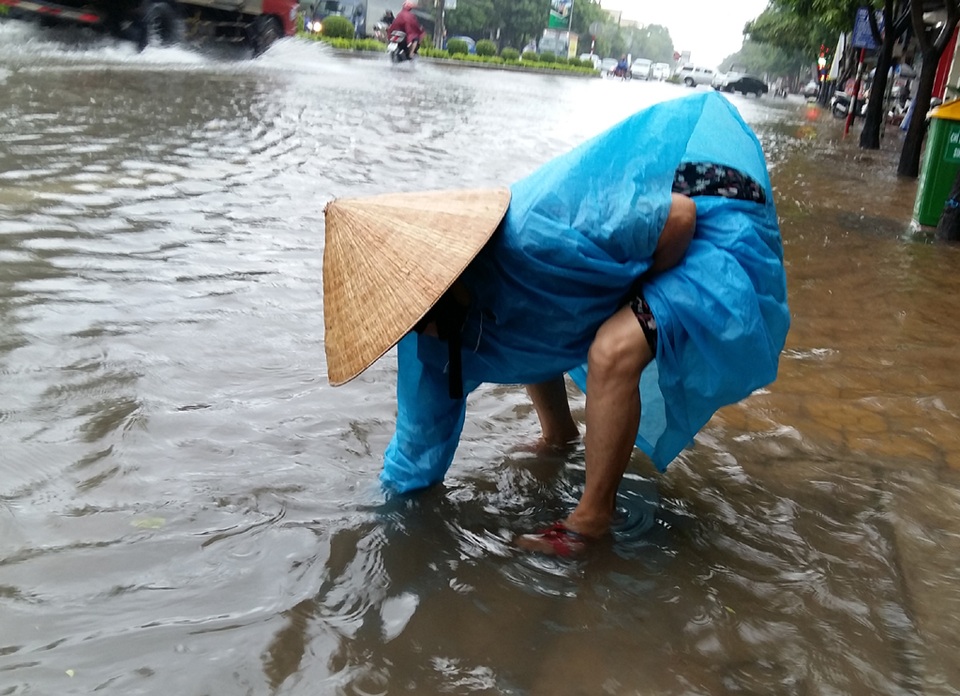Cây đổ la liệt sau bão số 4, mưa ngập nhiều nơi - 22 Người dân phải moi rác thông miệng cống để nước không tràn vào nhà.