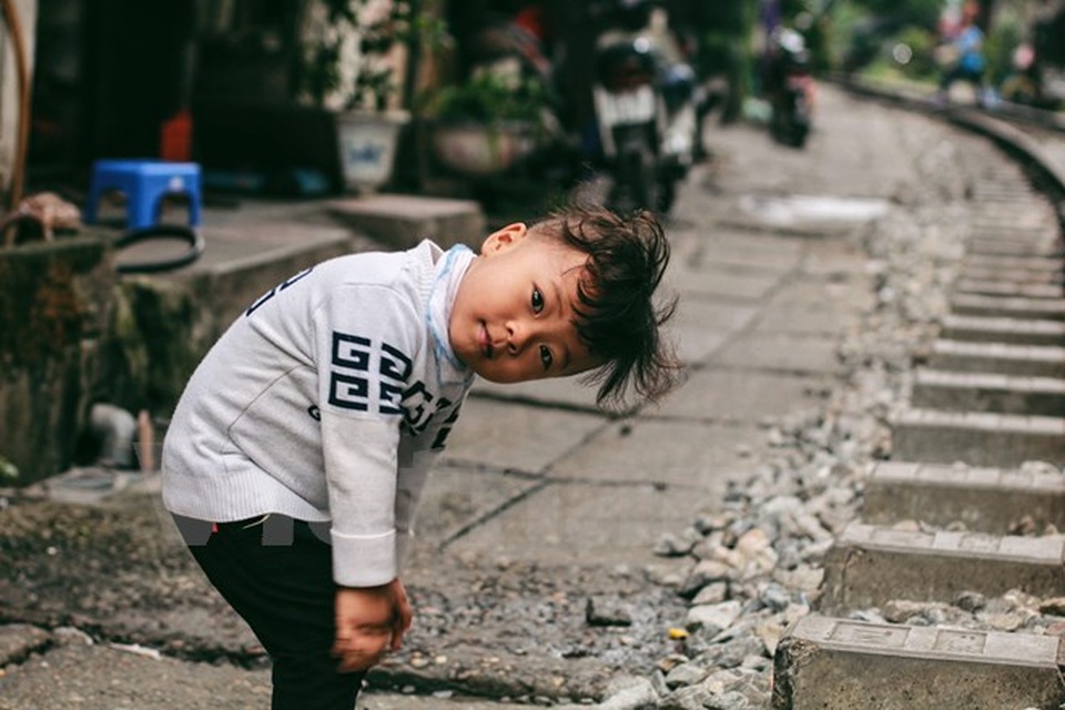 Những "mảnh" tuổi thơ trên phố đường tàu Lê Duẩn - 7 Sự hồn nhiên của đứa trẻ ngay bên cạnh con đường ẩn chứa nhiều nguy hiểm (Ảnh: Thanh Dung/Vietnam+)