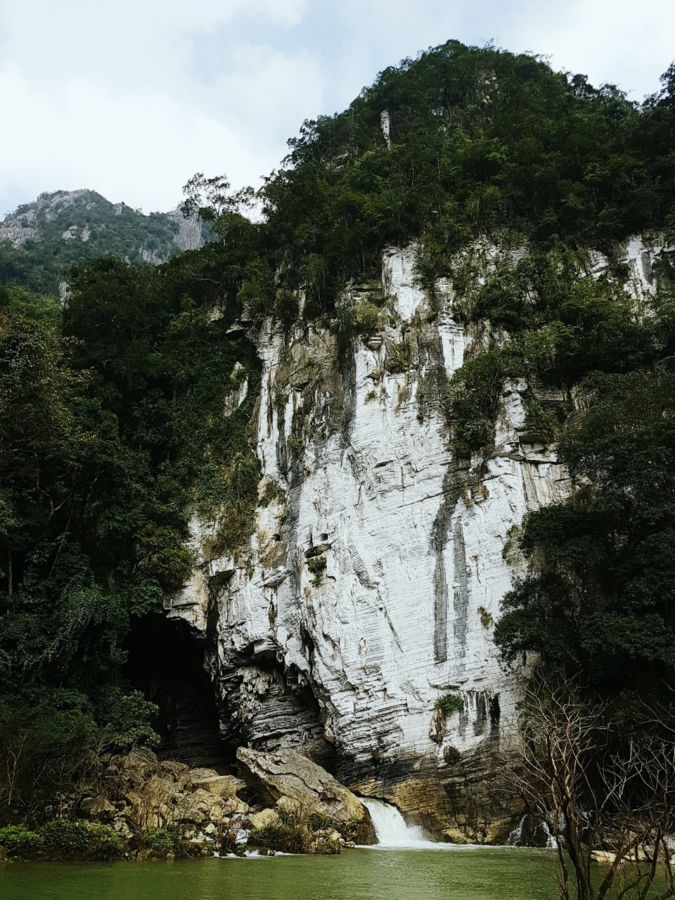 Một góc chụp khác từ phía ngoài hang với núi đá vôi sừng sững, hồ nước xanh như màu ngọc bích và dòng thác nhỏ tung bọt trắng xóa đều được ghi lại chi tiết bằng Galaxy S7 edge. Trong hành trình trải nghiệm, chúng tôi phải vượt qua rất nhiều thác ghềnh, sông suối. Những lúc này Galaxy S7 edge đã thể hiện bản lĩnh chống nước vượt trội của mình nhờ IP 68, trong khi các dòng máy khác phải cần đến sự hỗ trợ từ trưởng đoàn nhằm đảm bảo an toàn cho thiết bị.