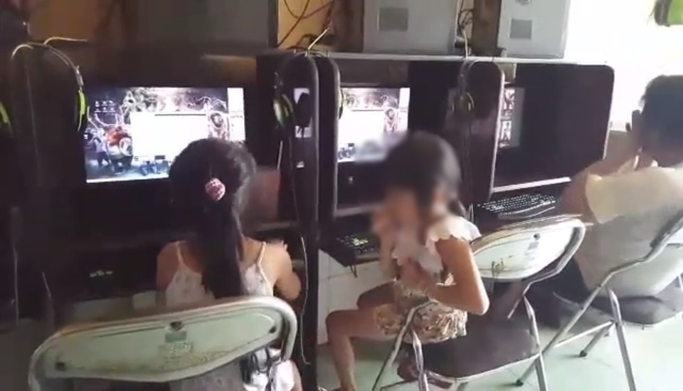 Clip bé gái trong quán net hút thuốc "như người lớn" khiến cư dân mạng phẫn nộ - 1 Bé gái đưa điếu thuốc lên và hút một cách hồn nhiên. (Ảnh cắt từ clip)