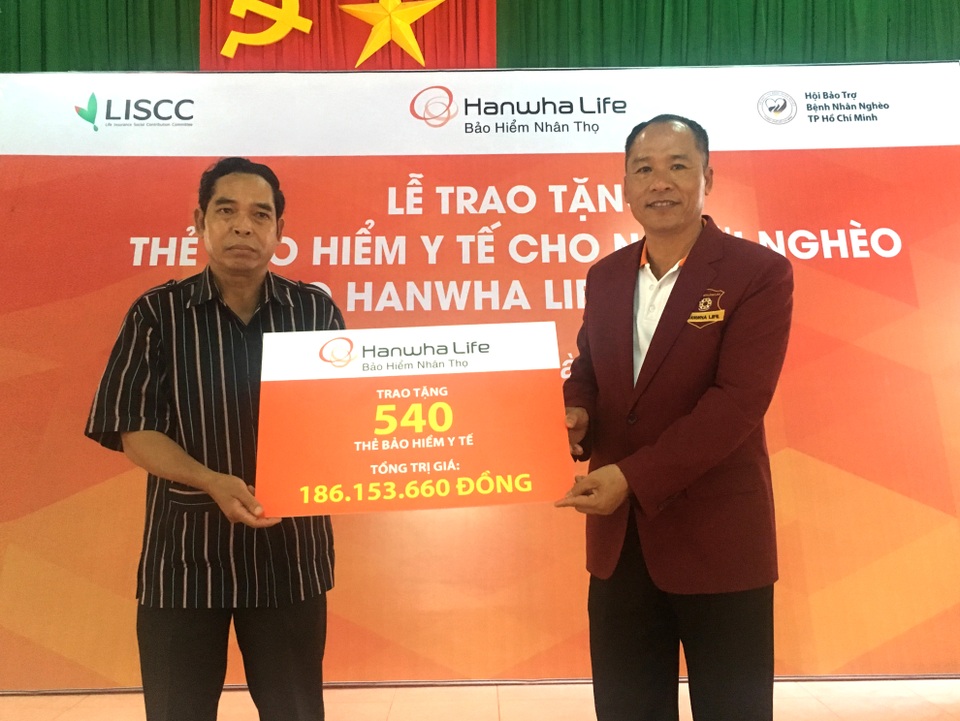 Doanh nghiệp Việt tặng 540 thẻ bảo hiểm y tế cho người nghèo - 1 Đại diện Hanwha Life Việt Nam tại Đắc Nông đang trao bảng tượng trưng thẻ bảo hiểm y tế cho chính quyền địa phương.