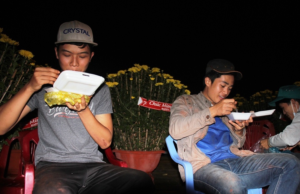 Thâu đêm "gác hoa": Vừa lo mưa gió lại sợ... xin đểu - 3 Anh Nguyễn Đảo (25 tuổi, bên phải) cùng 2 người bạn ăn vội hộp cơm bụi để tiếp thị hoa cho khách