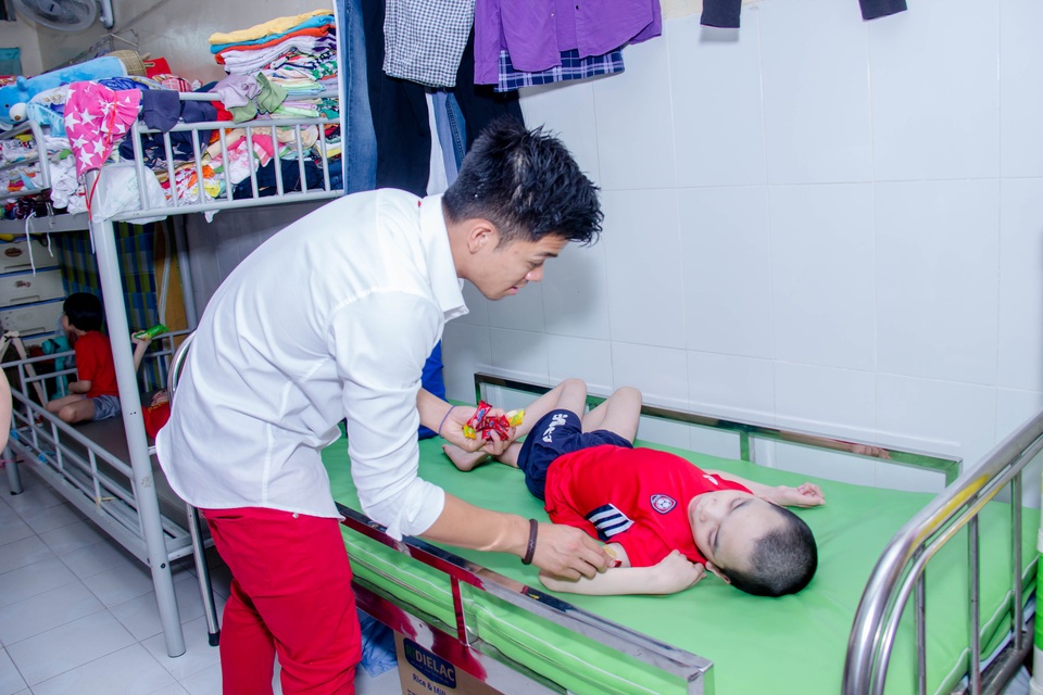 Hình ảnh nghệ sĩ Việt trong những chuyến từ thiện cuối năm - 12 Nụ cười của nam ca sĩ khi được trao quà cho một em nhỏ và anh cũng đi đến từng giường để trao quà cho các em không thể đi lại.