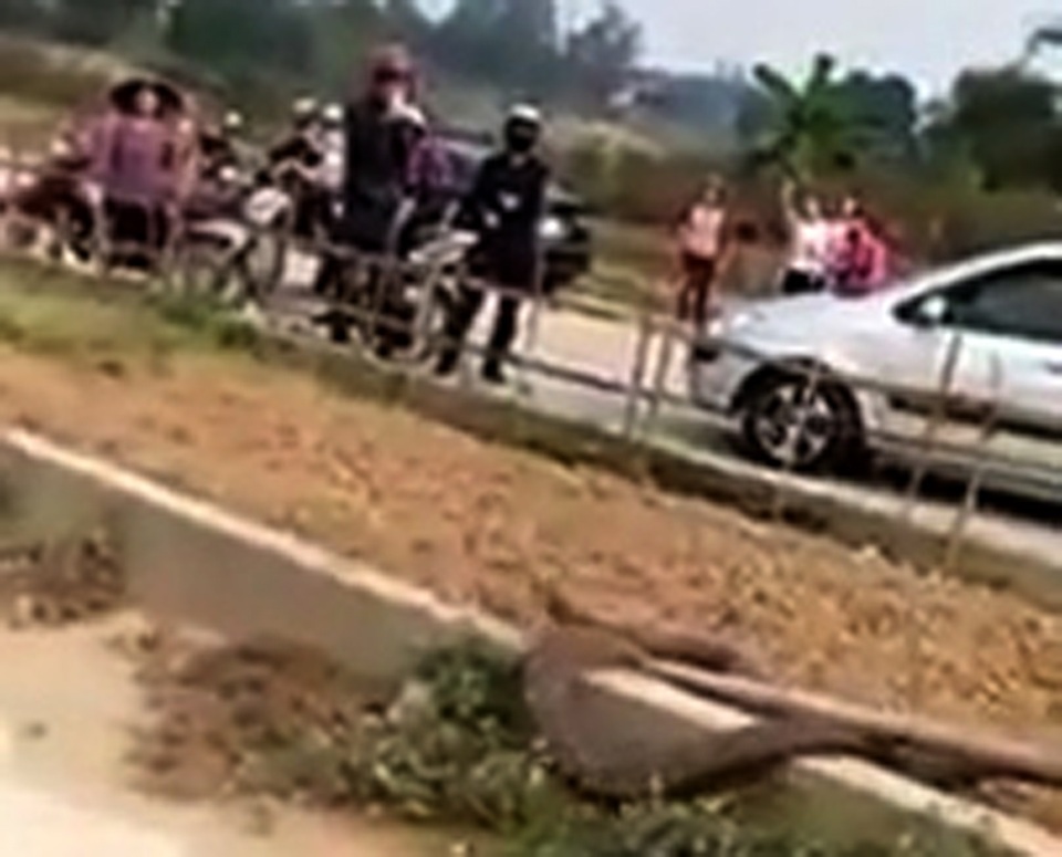 Nhiều người dân theo dõi quá trình bắt rắn hổ mang của nhóm người đàn ông (Ảnh cắt từ clip).