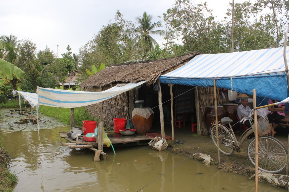 Căn nhà lá cũ nát của gia đình được che thêm những tấm bạt nhựa để chống dột