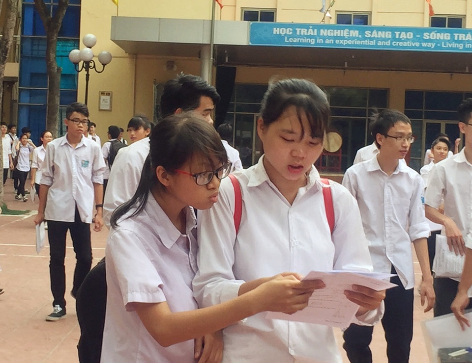 Đề Toán khá dài, có tính phân loại cao - 3 Thí sinh xem lại đề Toán sau khi rời phòng thi ở điểm trường THPT Lômônôxốp, Hà Nội. (Ảnh: Lệ Thu)