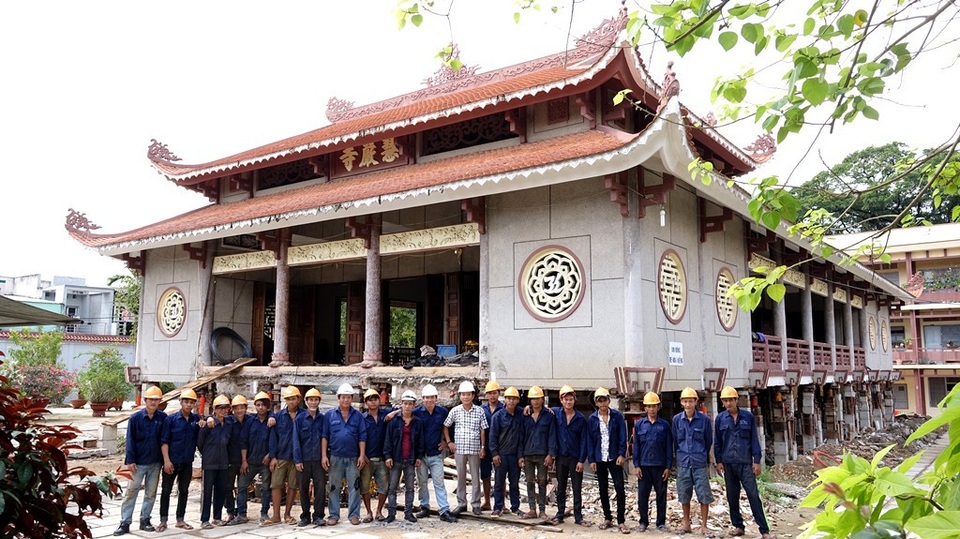 Ông Cư (áo trắng) và đội ngũ công nhân của mình bên ngôi chánh điện nặng 2000 tấn