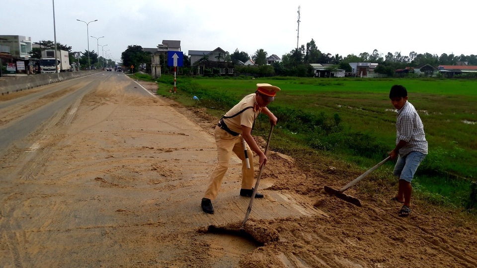 Xe đầu kéo đổ "núi" chất thải xuống quốc lộ rồi bỏ chạy - 1 Khi chất thải đổ cả núi xuống đường, lực lượng CSGT phải thu dọn để xe lưu thông an toàn