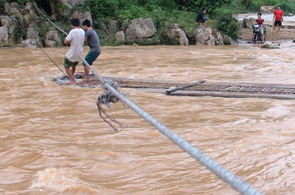 Nước lũ dâng cao chia cắt hàng trăm hộ dân - 3
Người dân muốn qua sông phải đi bè, mảng và đu bám bằng dây thừng, rất nguy hiểm