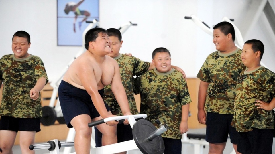 Lò luyện khắc nghiệt cho trẻ em béo phì Trung Quốc - 1
Trong căn phòng tập luyện tại ngoại ô Hàng Châu, 36 đứa trẻ cùng các thiếu niên mập mạp lắng nghe nghiêm túc sự hướng dẫn từ huấn luyện viên trong hành trình giảm cân đầy khắc nghiệt. Trong bài luyện tập vận động, những bạn nhỏ tập các động tác chân, tay, nằm nâng trên nền âm nhạc sôi động và tiếng hô cổ động từ huấn luyện viên nhằm động viên các em vượt qua sự mệt mỏi và kiệt sức để tiếp tập luyện. (Anh: Imaginechina)