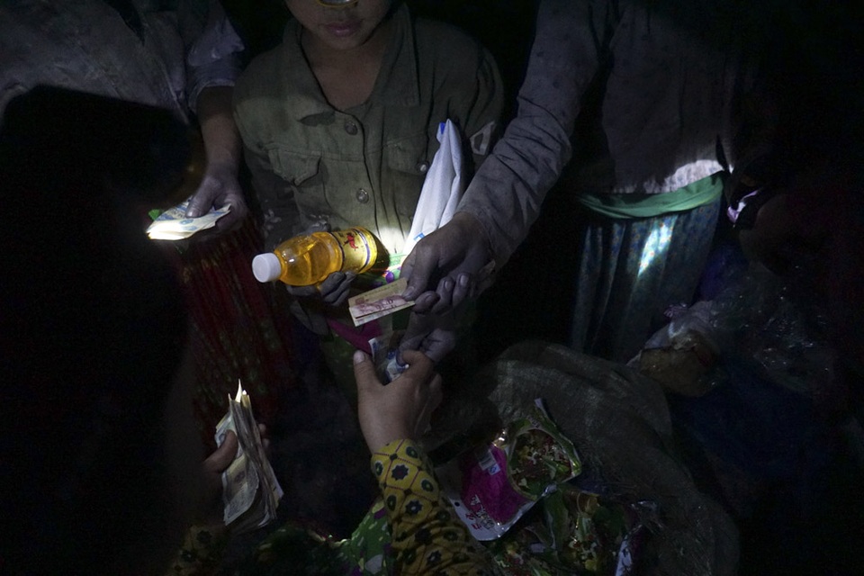 Đêm trắng ở vùng rốn quặng miền biên ải - 12 
Sau khi bán quặng, người lớn cất tiền mang về. Trẻ nhỏ lập tức trích một số nhỏ tiền để mua nước ngọt, bánh kẹo ăn uống ngay tại bãi thải khi cơ thể mệt mỏi vì mấy tiếng đồng hồ mót quặng.