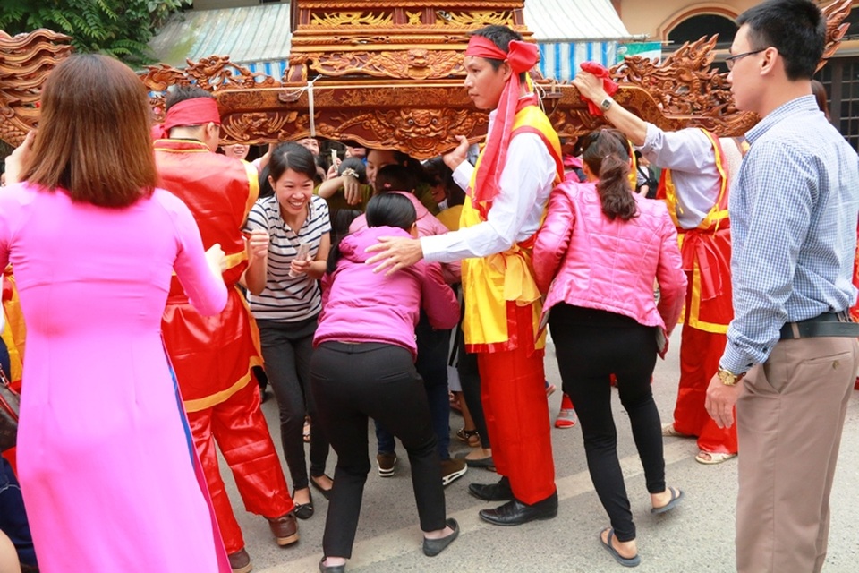 Những chỗ người dân đứng đông chờ kiệu qua, mọi người phải xếp hàng chui kiệu. Niềm vui hiện rõ trên khuôn mặt từng người khi được chui qua kiệu.
