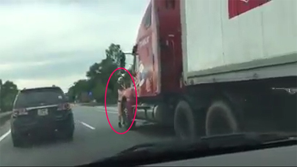 Kinh hãi Thượng úy CSGT bị xe container đẩy đi hàng trăm mét - 1 Chiến sĩ CSGT mắc kẹt trước mũi container bị kéo lê hàng trăm mét. (Ảnh cắt từ clip)