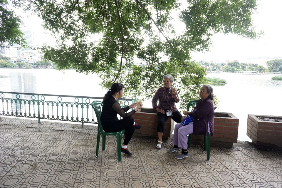 
Người cao tuổi trò chuyện bên hồ Trúc Bạch, hít hà không khí lạnh ngọt cuối thu.
