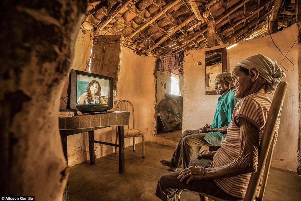 Bức “TV School” (Trường học trong chiếc TV) ở hạng mục Con người, do nhiếp ảnh gia Alisson Gontijo (Brazil) chụp tại Aracuai, Brazil. Một cặp vợ chồng lớn tuổi đang ngồi xem chương trình xóa mù chữ qua truyền hình, TV đã có tác động rất lớn tới đời sống của những con người sống ở các miền quê xa xôi, hẻo lánh tại Brazil.