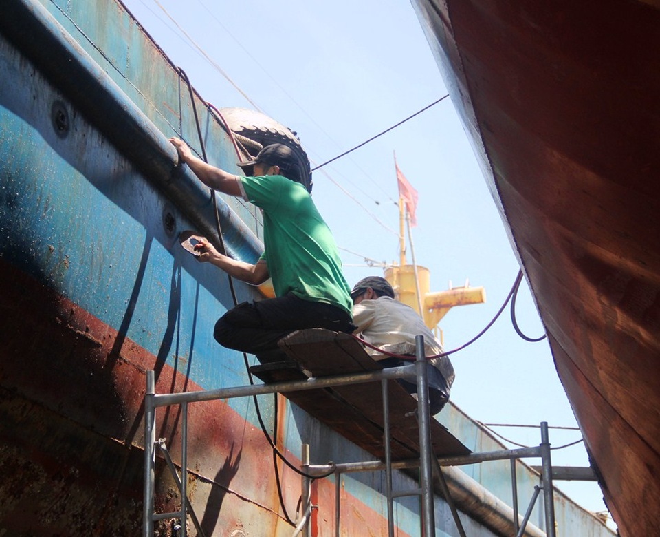 Toàn cảnh 5 tàu vỏ thép của Đại Nguyên Dương rỉ sét nham nhở - 12 Các công nhân đang dùng máy chà lớp hà bám và làm sạch bề mặt vỏ thép.