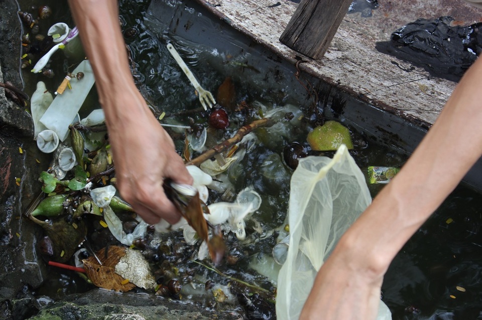 
Một người đàn ông chèo thuyền ra vớt loại rác thải đặc biệt này.
