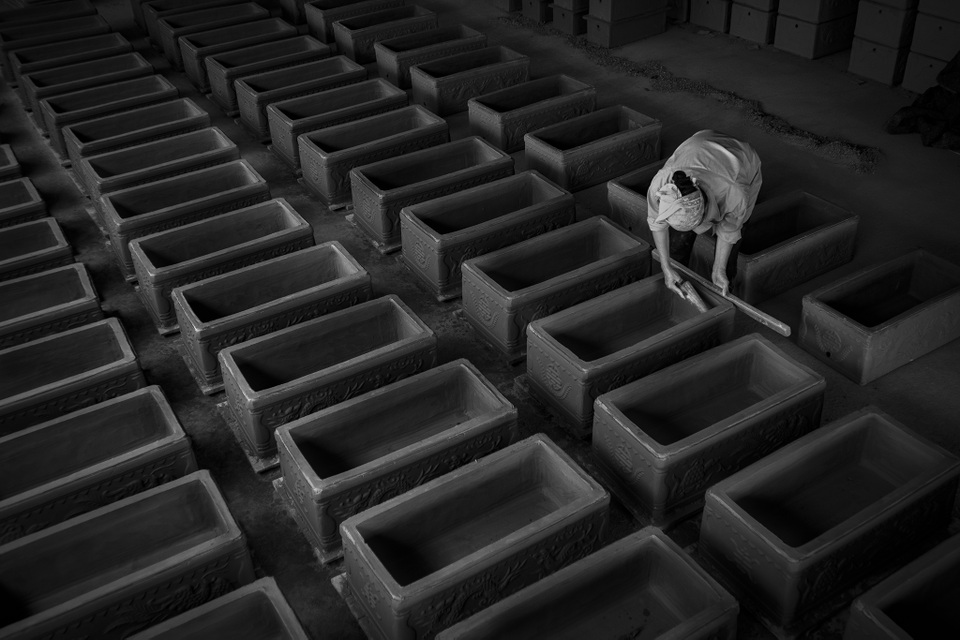 Ảnh đẹp trong ngày 11/5/2017. Một thợ thủ công hoàn thành quy trình cuối cùng trước khi đưa bình tiểu vuông vào lò nung. Theo truyền thống Việt Nam, khi người ta qua đời, cơ thể sẽ được chôn xuống mặt đất tự nhiên. Ba năm sau, sau một buổi lễ gọi là Cải Cát, cơ thể phân hủy hết chỉ những mẩu xương còn lại sẽ được chuyển đến các bình tiểu vuông để chôn cất vĩnh cửu. Trong các nghĩa trang lớn, có hàng ngàn những ngôi nhà như vậy nằm trong lòng đất.