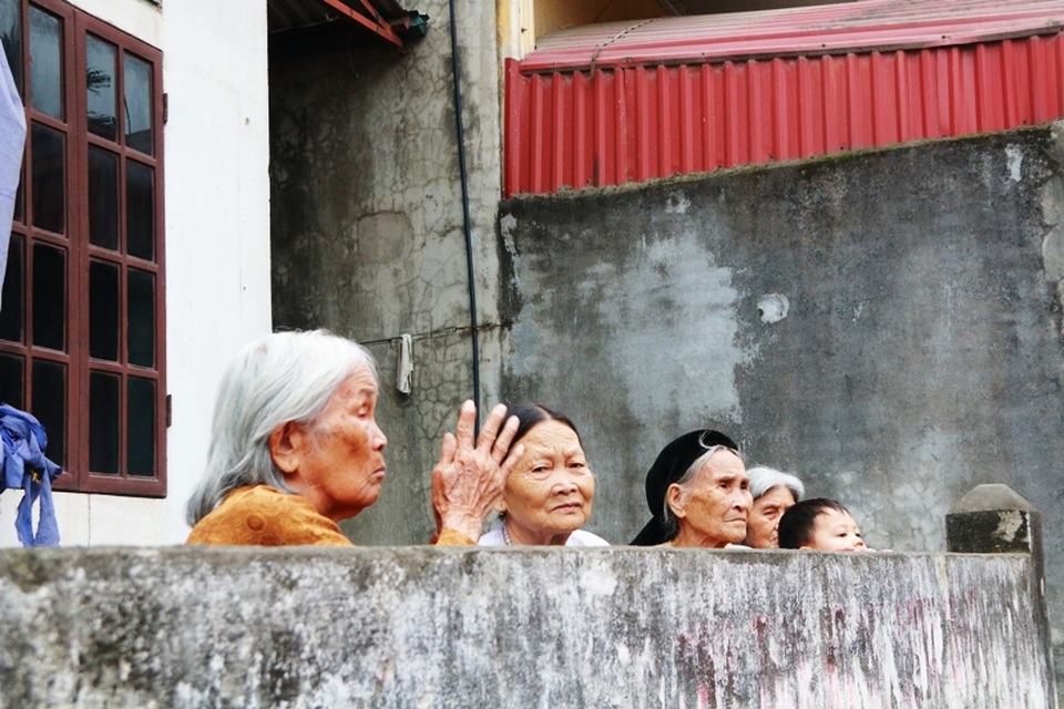Những cụ bà cao tuổi không xuống gần kiệu để chui qua được nên đã khấn vái từ xa để cầu nguyện.