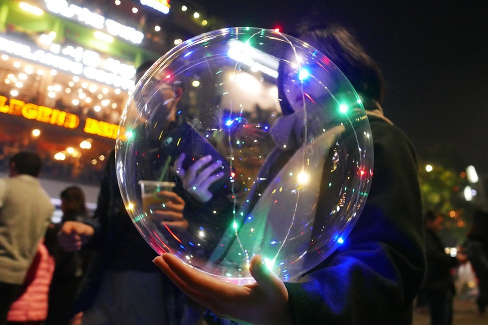 Biển người ở phố đi bộ hồ Gươm đón Giáng sinh - 4
Một bạn trẻ cầm trên tay quả bóng bay phát sáng - món đồ chơi xuất hiện nhiều ở phố đi bộ trong thời gian gần đây.