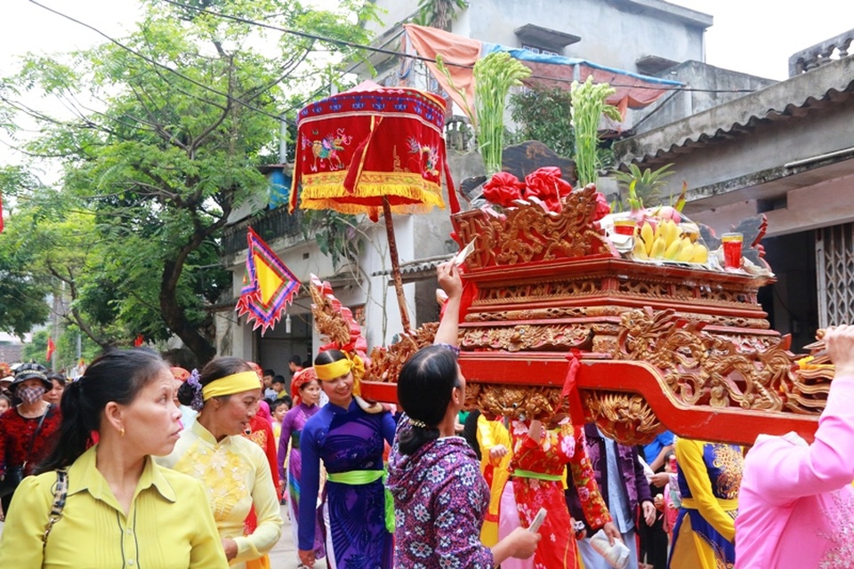 Trên suốt đoạn đường dài, người dân hai bên đường đua nhau ném tiền lẻ lên và chui qua kiệu.