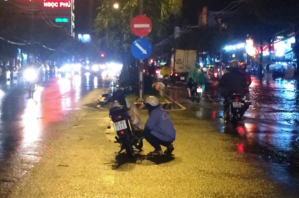 Một xe máy bị hỏng và người đàn ông này vô tư đậu giữa đường sửa xe