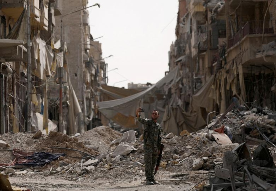 Ngày tàn của phiến quân IS tại thủ phủ Raqqa - 13
Một thành viên SDF chụp ảnh “tự sướng” trước đống đổ nát ở Raqqa.