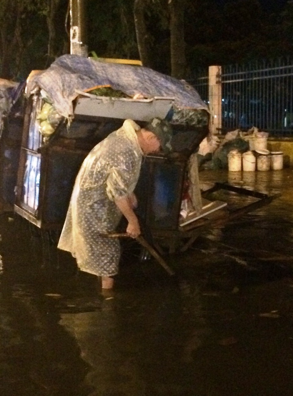 Một người dân đang cố gắng soi cống cho nước rút nhanh