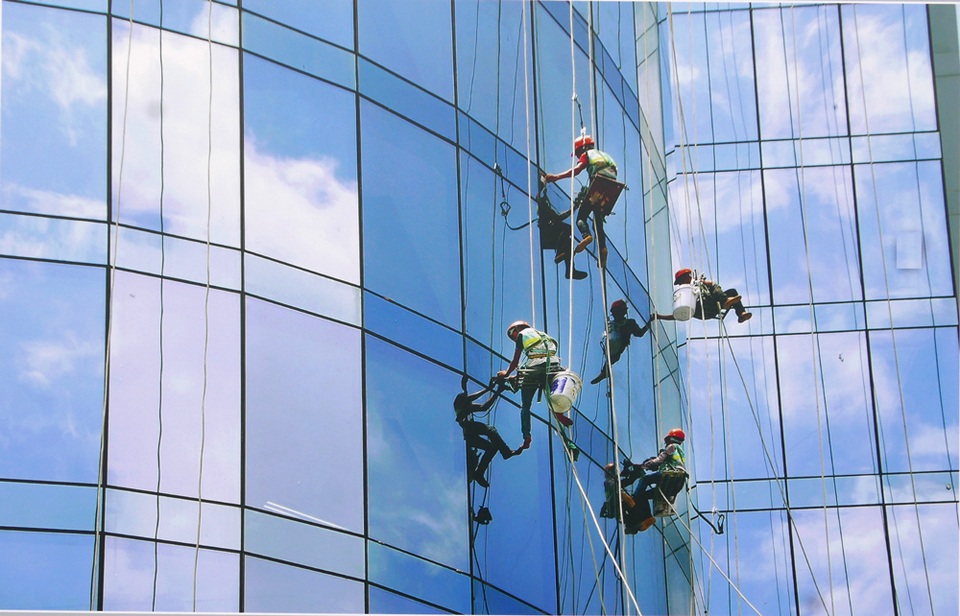 
Một bức ảnh khác của tác giả Đặng Linh chụp các công nhân đang lau kính trên một toà nhà cao tầng cho thấy hơi thở của nhịp sống đô thị hiện đại.
