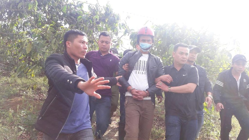 Giết người rồi chôn xác phi tang trong vườn cà phê - 2 Đối tượng Nguyễn Thành Đức (đội mũ bảo hiểm) bị áp giải đến hiện trường