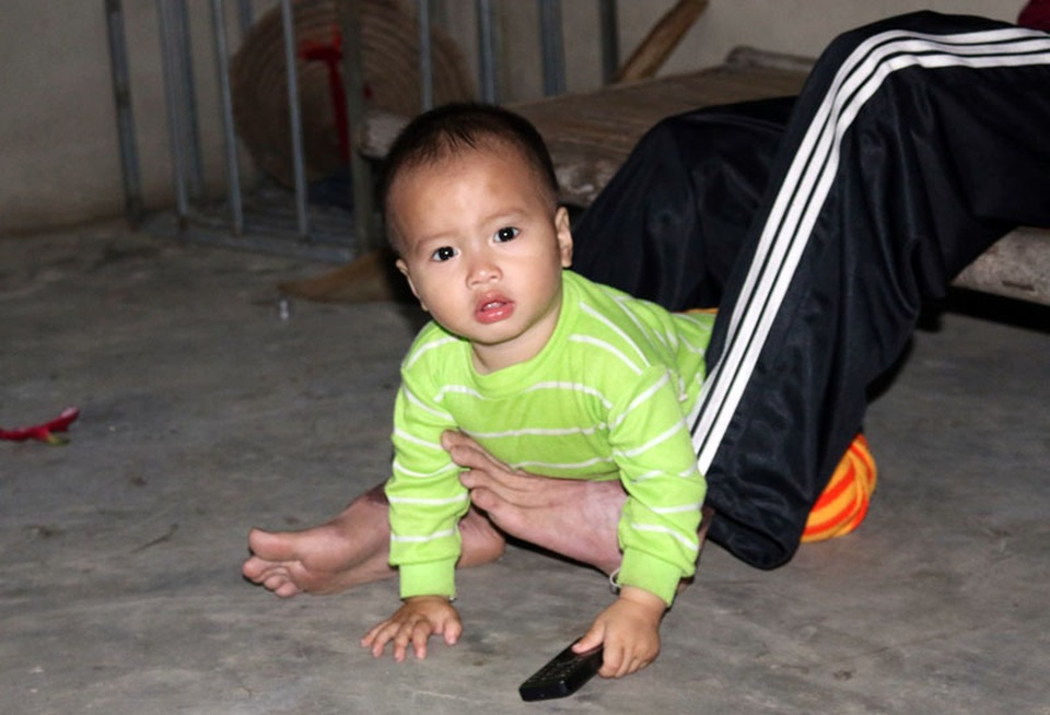 Rớt nước mắt cảnh người cha trẻ mất đôi tay chăm bé thơ khát sữa - 5 Không còn đôi tay Hải dùng chân đỡ con trai dậy mỗi khi con té xuống nền nhà.