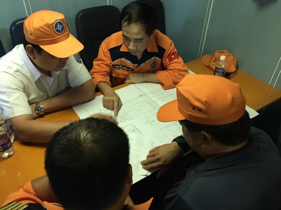 Vụ 9 người mất tích: Tăng cường thợ lặn tìm kiếm trong tàu - 1
Thuyền trưởng tàu Hải Thành 26 (áo cam) hướng dẫn sơ đồ tàu.