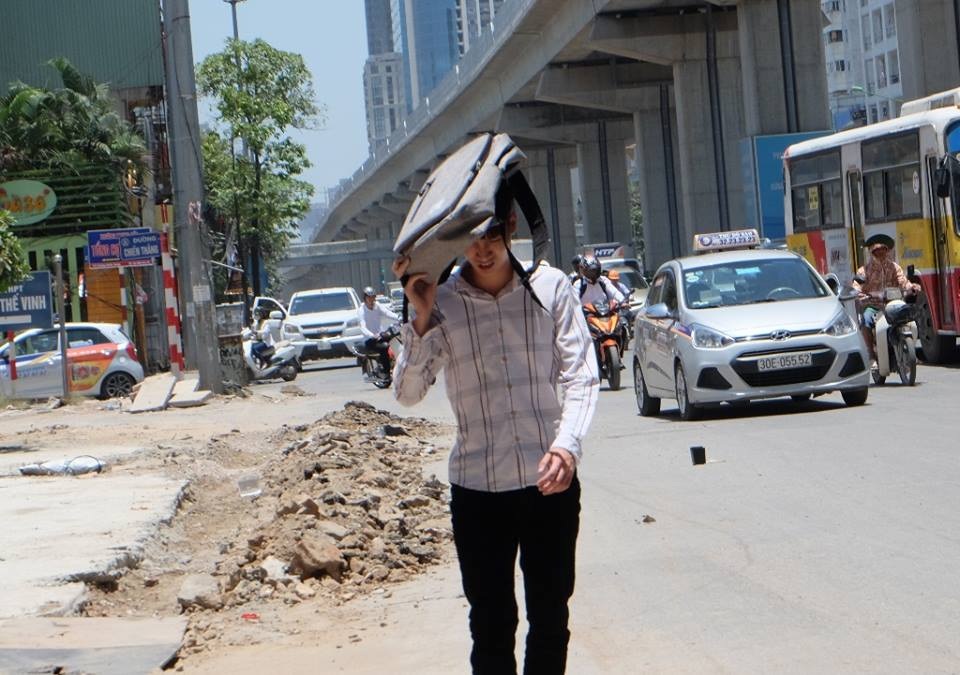 Muôn kiểu chống nóng “cực độc” của người Hà Nội trong đợt nắng kỷ lục - 6 Một thanh niên phải dùng ba lô che lên đầu tránh nắng