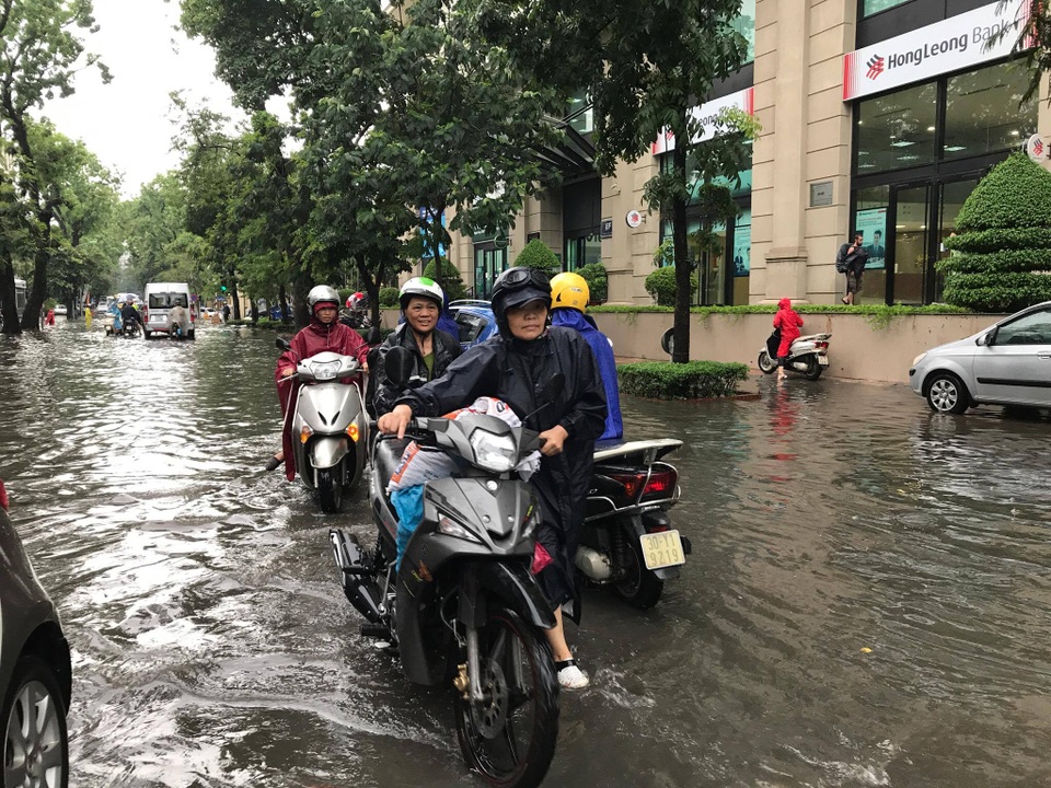 Hà Nội ngập, tắc nhiều nơi sau trận mưa lớn diện rộng - 6
Một phụ nữ lặc lè dắt chiếc xe chết máy trên đường Lý Thường Kiệt.