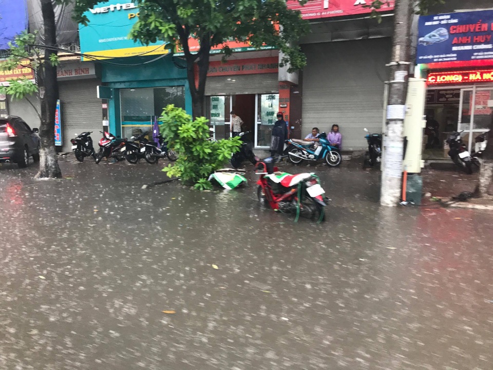 Hà Nội ngập, tắc nhiều nơi sau trận mưa lớn diện rộng - 1
Mưa lớn, ngập trên đường giải phóng. Nhiều người đi xe máy phải bỏ xe lại trên đường, chạy vào hiên nhà dân trú mưa.