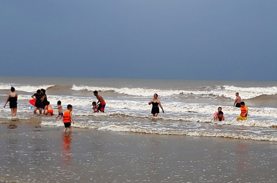 Bất chấp mưa bão, nhiều du khách vẫn "thản nhiên" tắm biển - 2 Những cột sóng biển đã bắt đầu cao dần lên