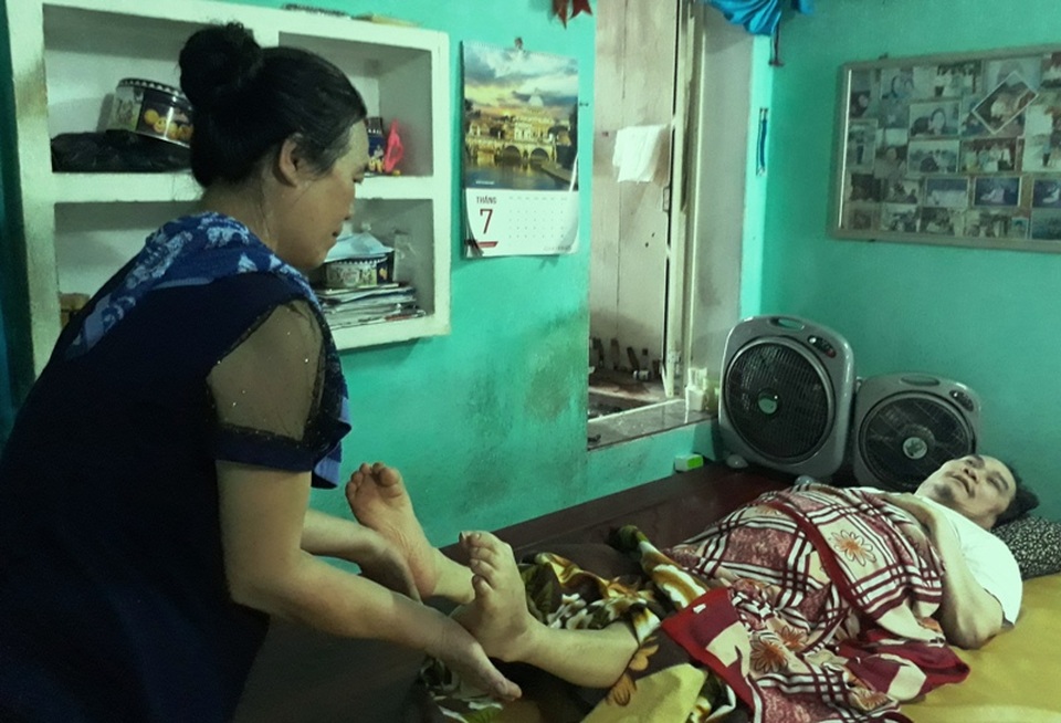 Nguyện làm “đôi chân” cho anh suốt đời - 2 Do di chứng của cơn đau nên bà Hạnh thường xuyên phải nắn chân cho chồng